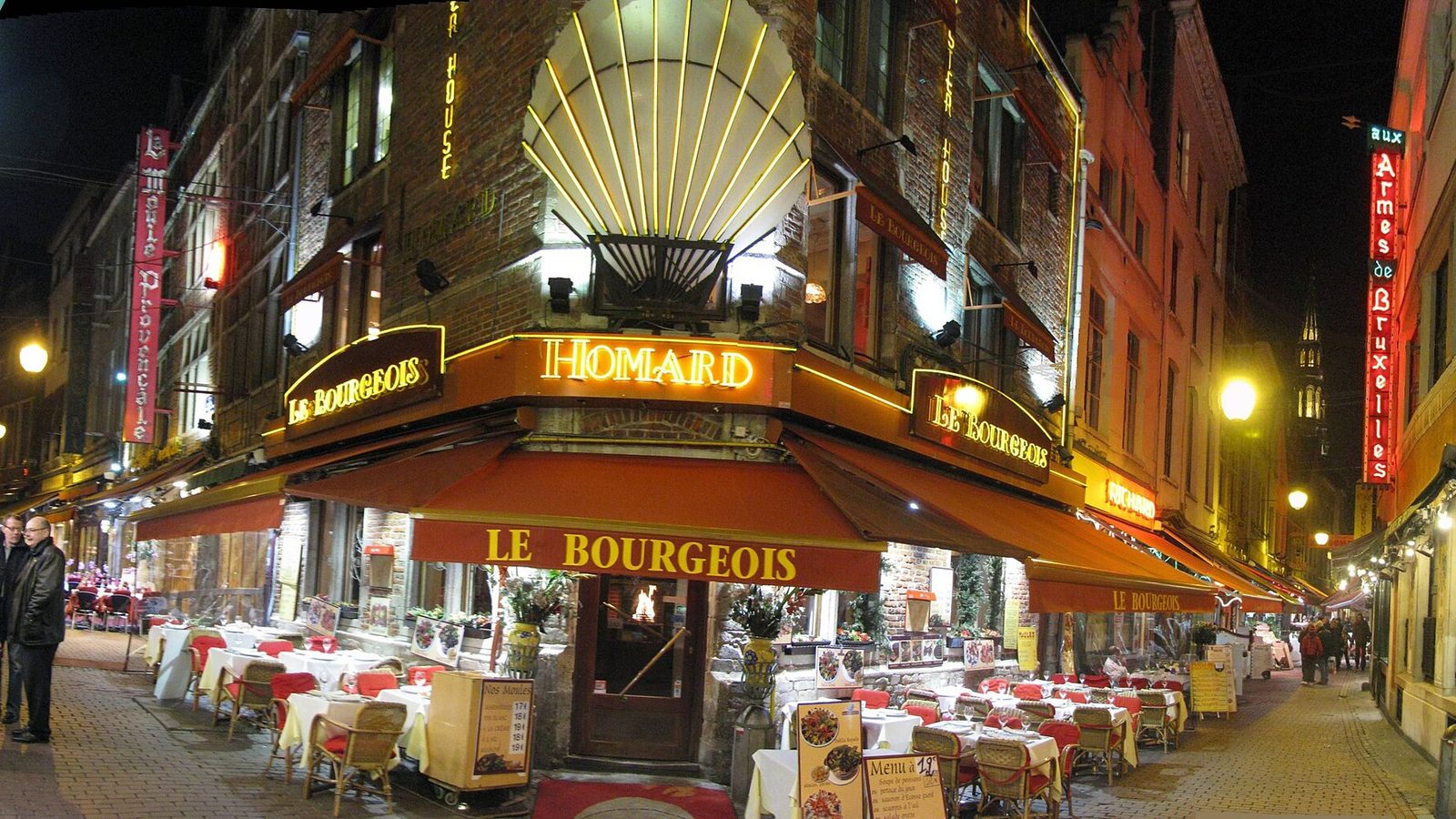 La petite rue des Bouchers à Bruxelles, de nuit, avec les enseignes lumineuses des restaurants